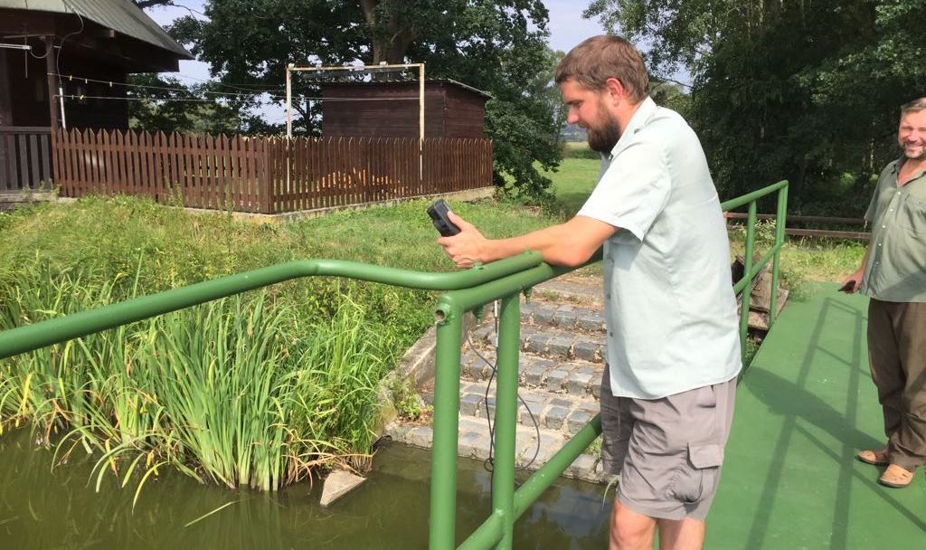 Rybář Lukáš Dědič měří pomocí sondy teplotu vody a množství kyslíku v rybníce Rabyň u Protivína