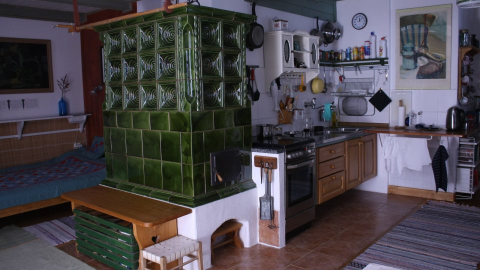 Krásná kachlová kamna jsou dominantou obývacího prostoru propojeného s kuchyní