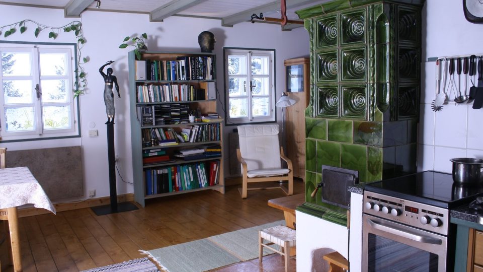 Krásná kachlová kamna jsou dominantou obývacího prostoru propojeného s kuchyní