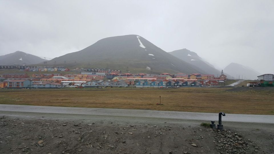 Asi dvoutisícové městečko Longyearbyen v centrální části Špicberků. Půl roku je tu nestále světlo, půl roku tma. Také proto velká část obyvatel odjíždí na zimu na pevninskou část Norska