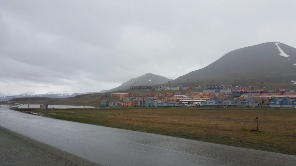 Asi dvoutisícové městečko Longyearbyen v centrální části Špicberků. Půl roku je tu nestále světlo, půl roku tma. Také proto velká část obyvatel odjíždí na zimu na pevninskou část Norska