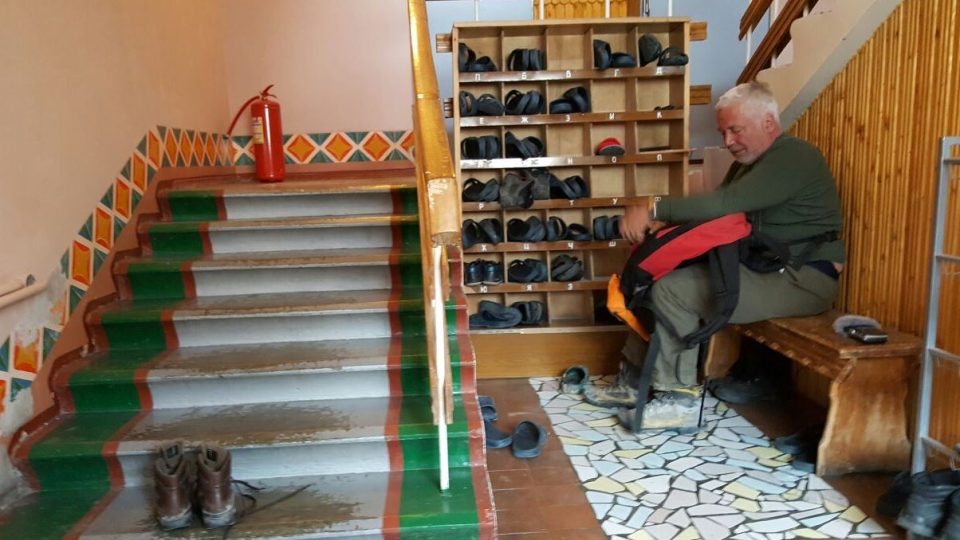 Parazitolog Oleg Ditrich si zouvá boty před vstupem do baru v bývalé hornické osadě Pyramiden na Svalbardu