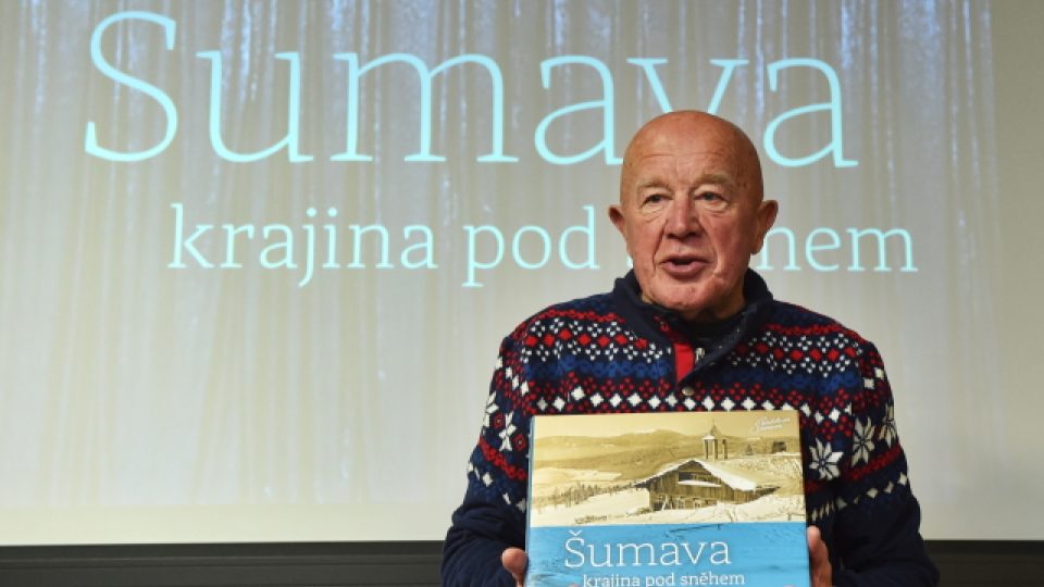 Jeden z pamětníků a milovníků lyžování Emil Kintzl z Kašperských Hor ukazuje knihu Šumava - krajina pod sněhem