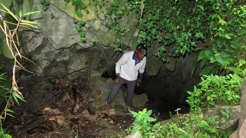 Vstup do jeskyně Hagepma a místní průvodce Onesius Lokobal, díky kterému čeští vědci vůbec prvního jeskynního raka na jižní polokouli a nový druh švába objevili