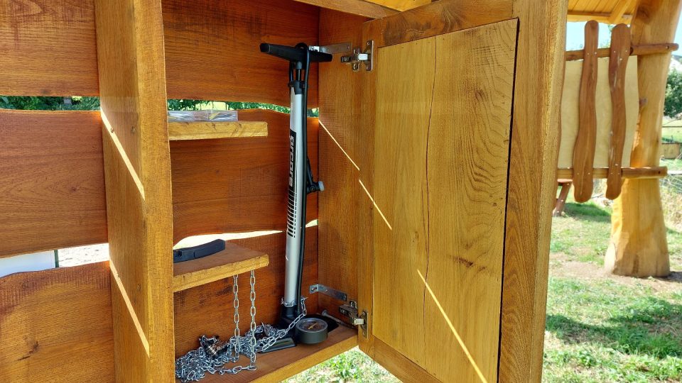 Na zadní straně tabule s mapou je umístěna skříňka s nářadím pro cyklisty