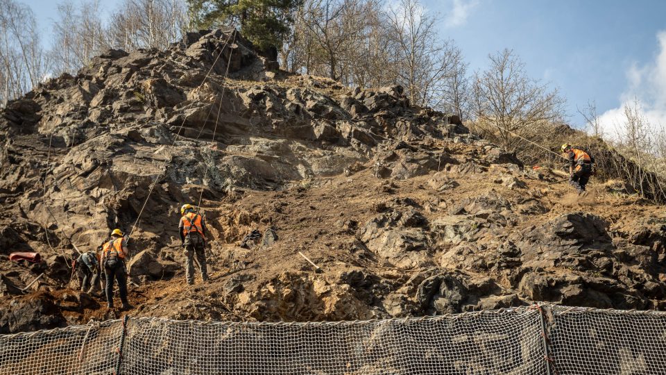 Nebezpečnou skálu u silnice mezi Českým Krumlovem a Větřním zajišťují dělníci z odborné firmy