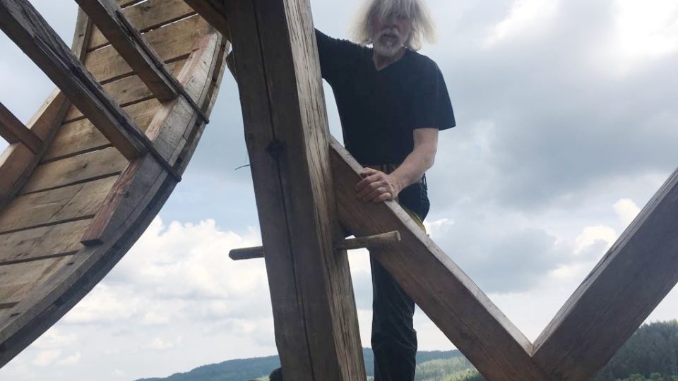 Tesař Petr Růžička promazává navíjecí mechanismus dřevěného jeřábu na věži Jakobínka