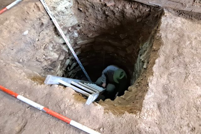 Archeolog Martin Pták prozkoumává studnu | foto: Kristýna Barchini,  Český rozhlas